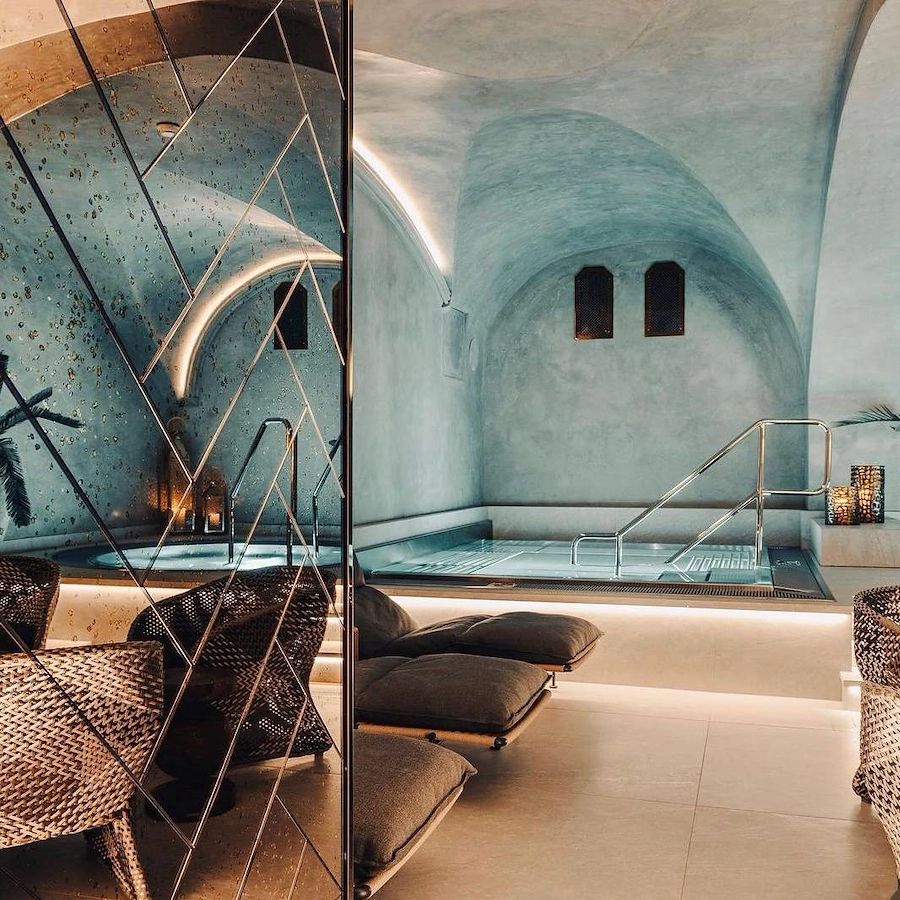 Glimt in i poolrummet på Vimmerby Stadshotell Spa – stilla turkost vatten, bubbelpool, valvformat tak och sköna loungebäddar i en unik miljö för avkoppling.